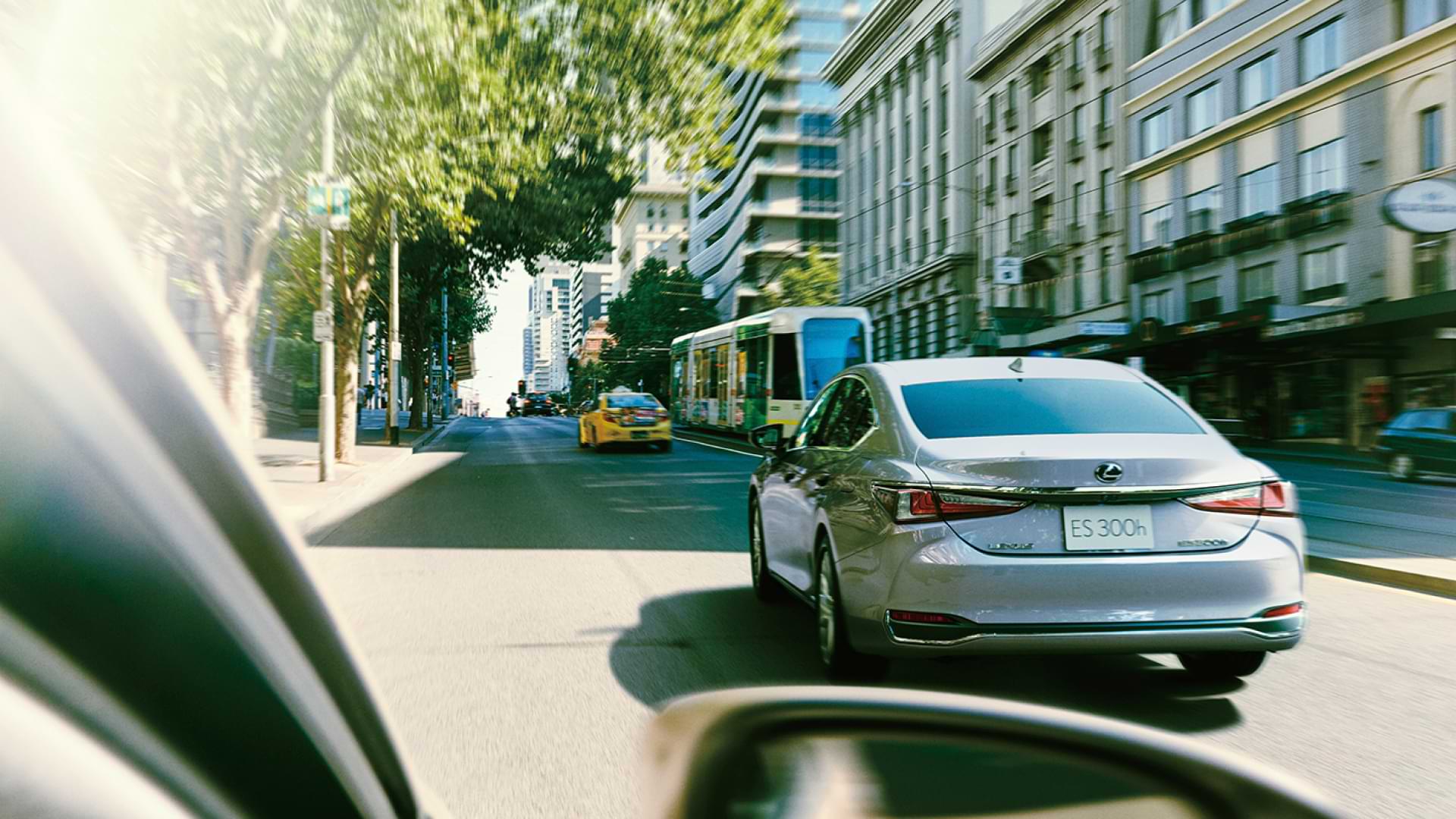 ES 300h drives down a Melbourne street. A tram and taxi can be seen ahead.